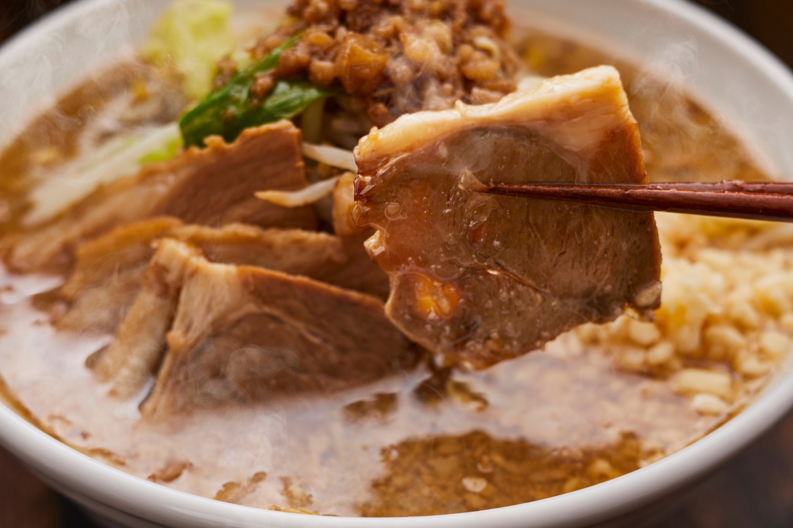 新日食のラーメンを箸で持ち上げる様子